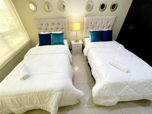 two beds sitting next to each other in a bedroom at Ecuabook OmniHospital Torre Sol 702 in Guayaquil