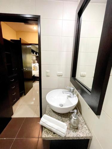 a bathroom with a sink and a mirror at Ecuabook OmniHospital Torre Sol 702 in Guayaquil