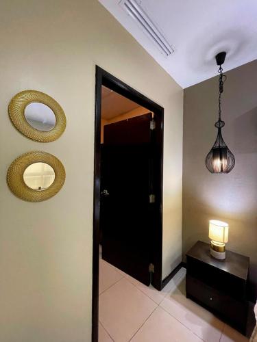 a hallway with a black door and a mirror at Ecuabook OmniHospital Torre Sol 702 in Guayaquil