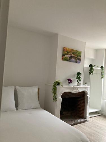 une chambre blanche avec un lit et une cheminée dans l'établissement Travel Tokyo, à Sens