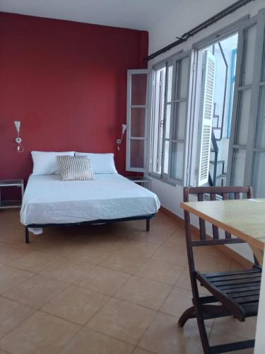 a bedroom with a bed and a red wall at Maison Sevilla in Larache