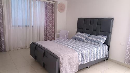 a bedroom with a large bed with a black headboard at Comfortable and perfect location in Lechería in El Morto de Barcelona