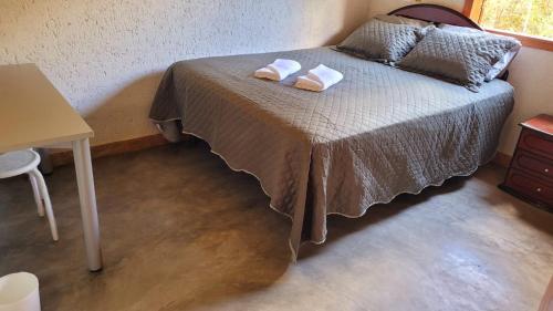 una camera da letto con un letto con due asciugamani sopra di Casa Rústica Próxima ao Distrito de Milho Verde, 3 QUARTOS - São Gonçalo do Rio das Pedras, Serro a Sêrro