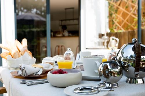 einen Tisch mit Essen und einen Wasserkocher darauf in der Unterkunft Ferret Vigne - Villa Chambres d'Hôtes in Cap-Ferret