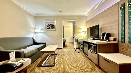 a hotel room with a couch and a television at Quality Inn & Suites Los Angeles Airport - LAX in Inglewood