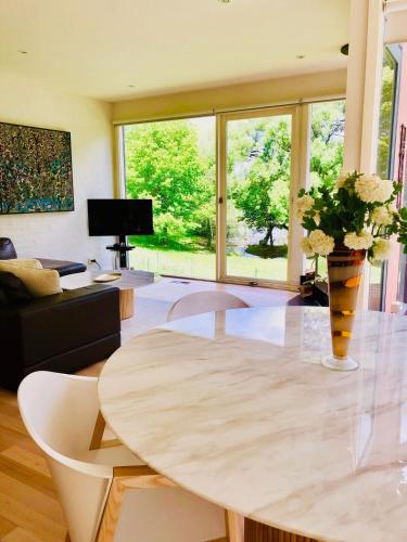 a living room with a table with a vase of flowers at Lake Daylesford Villa2 Lake frontage pet friendly in Daylesford