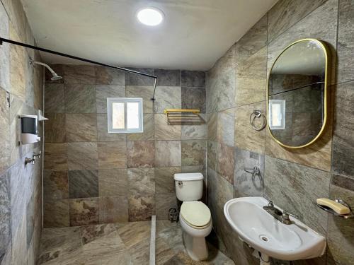 a bathroom with a toilet and a sink and a mirror at Casa Palma in Xochitepec