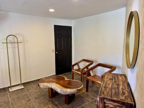 a room with two chairs and a table and a mirror at Casa Palma in Xochitepec
