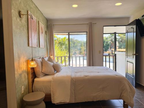 a bedroom with a large bed and a balcony at Casa Palma in Xochitepec
