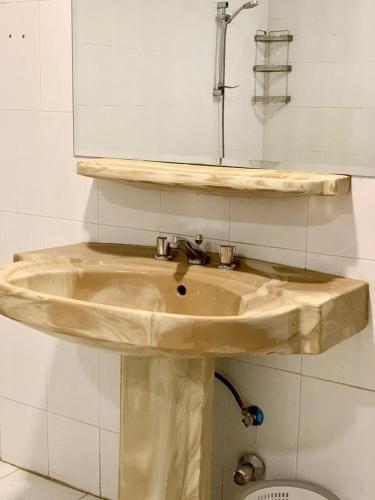 a sink in a bathroom with a mirror above it at Rest house in Abha