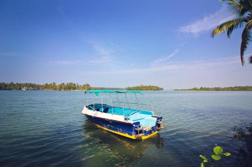 a blue and white boat sitting in the water at Paradise Lagoon in Kalyānpur