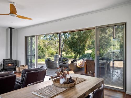 a living room with a table and a large glass window at The Deck - Margaret River NEW in Margaret River Town