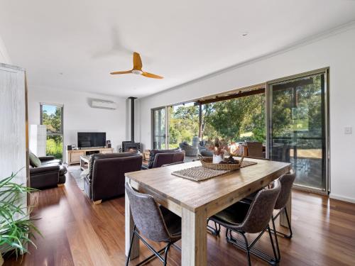 a living room with a wooden table and chairs at The Deck - Margaret River NEW in Margaret River Town