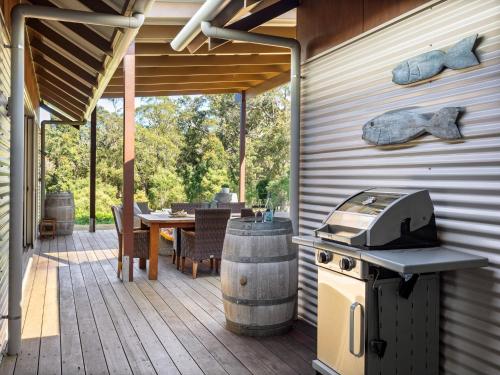 a outdoor patio with a grill and a table with chairs at The Deck - Margaret River NEW in Margaret River Town