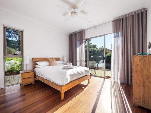 a bedroom with a bed and large windows at The Deck - Margaret River NEW in Margaret River Town