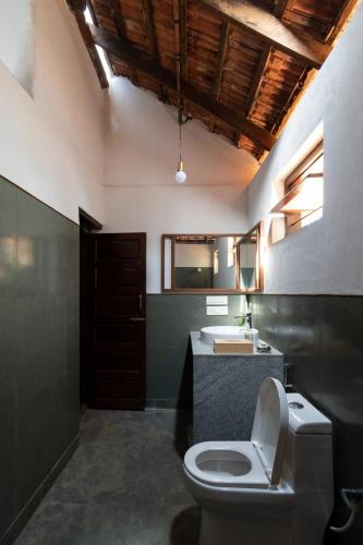 a bathroom with a toilet and a sink at Chitrabanu Estate Inn in Ammatti