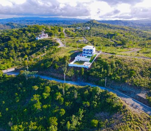 an aerial view of a house on a hill with a river at Beautiful ocean and mountain view villa in Gaspar Hernández