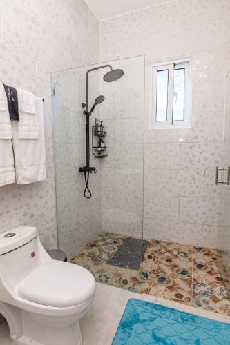 a bathroom with a toilet and a glass shower at Beautiful ocean and mountain view villa in Gaspar Hernández