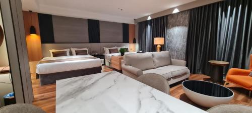 a hotel room with a bed and a living room at Extreme Boutique Hotel in Kluang