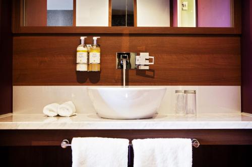 a sink in a bathroom with towels on a counter at San Pietro Hotel & Restaurant in Scunthorpe