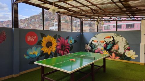 a ping pong table in a room with a mural at Bolivian Heights Hostel in La Paz