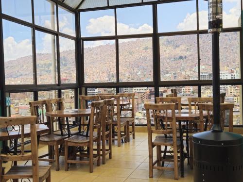 a restaurant with tables and chairs in front of a window at Bolivian Heights Hostel in La Paz