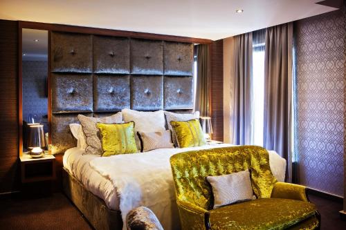 a bedroom with a large bed and a chair at San Pietro Hotel & Restaurant in Scunthorpe