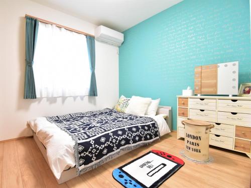 a bedroom with a bed and a blue wall at Inn光楽縁 in Okayama