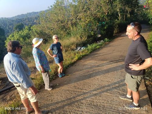 a group of people standing on a dirt road at Spice Villa Thekkady in Thekkady
