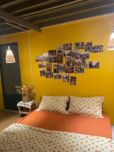 a bedroom with an orange bed and a yellow wall at Chang ơi homestay Sai Gon in Ho Chi Minh City