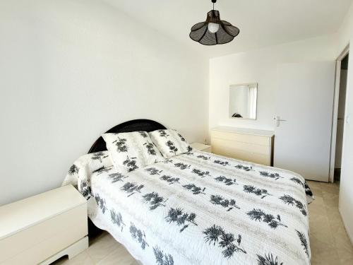 - une chambre blanche avec un lit et une tête de lit noire dans l'établissement Canet-en-Roussillon - T2 cabine - 6 pers - Garage fermé - WIFI - FR-1-794-126, à Canet
