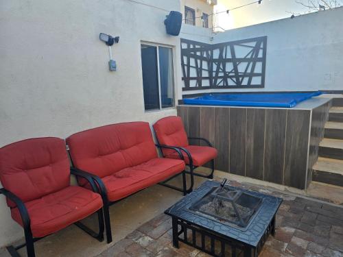 three red chairs and a coffee table in a room at De la llanura 31 in Hermosillo