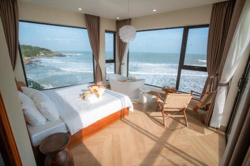 a bedroom with a bed and a view of the ocean at Sunsea House-Đá Đĩa Phú Yên in Tuy An
