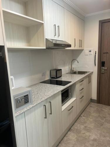 a kitchen with white cabinets and a sink at 1106 LaGrande2 11floor rooftop swiming angeles Walking street in Angeles