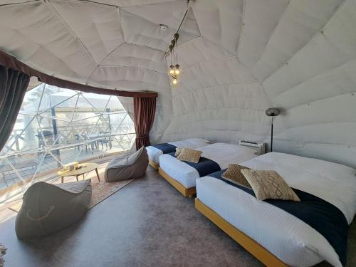 two beds in a room with a large window at lastpiece in Itoshima