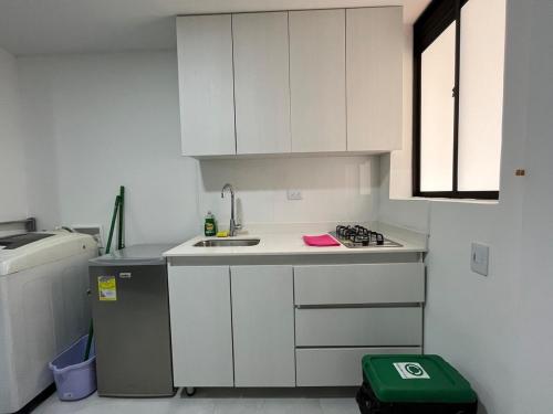 a small kitchen with white cabinets and a sink at Económico apartamento en el centro de la ciudad in Medellín