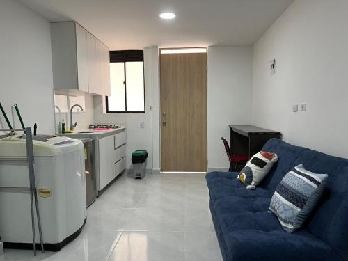 a living room with a blue couch in a kitchen at Económico apartamento en el centro de la ciudad in Medellín