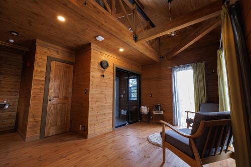 a living room with wooden walls and a wooden floor at lastpiece in Itoshima