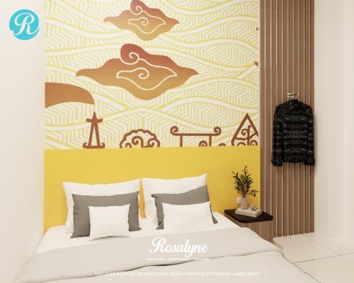 a bedroom with a bed with a yellow wall at Rosalyne House Malioboro 2 in Sentool