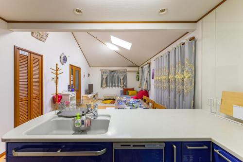 a kitchen with a sink and a living room at Nakano Shinjuku Sapphire Single-family House in Tokyo