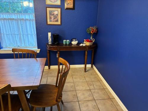 a dining room with a table and a blue wall at The House on Wertz in Mena