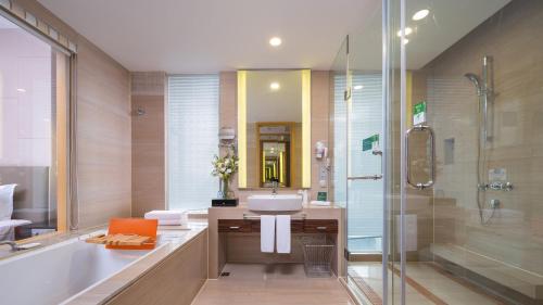 a bathroom with a tub and a sink and a shower at Holiday Inn Nanchang Riverside by IHG in Nanchang