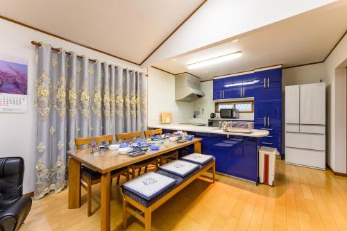 a kitchen with blue cabinets and a table and chairs at Nakano Shinjuku Sapphire Single-family House in Tokyo