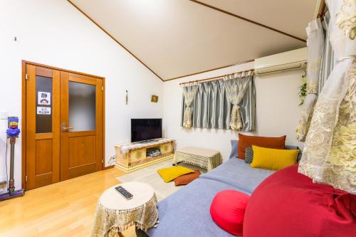 a living room with a couch and a tv at Nakano Shinjuku Sapphire Single-family House in Tokyo