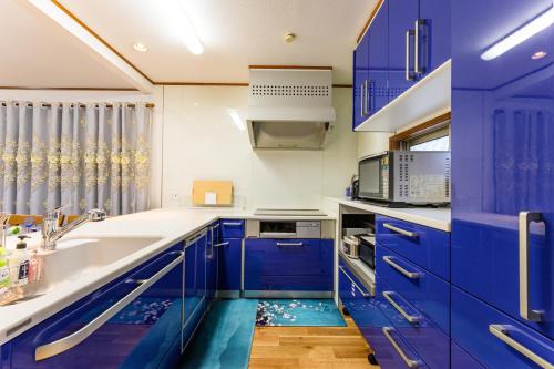 a blue kitchen with blue cabinets and a sink at Nakano Shinjuku Sapphire Single-family House in Tokyo