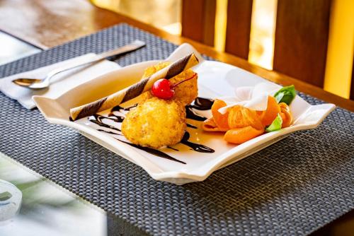 a white plate with food on a table at Blue Star Dive and Resort in Anda