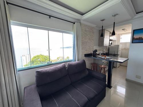 un salon avec un canapé et une cuisine dans l'établissement Apartamento com Vista Única e Maravilhosa !!!, à São Vicente