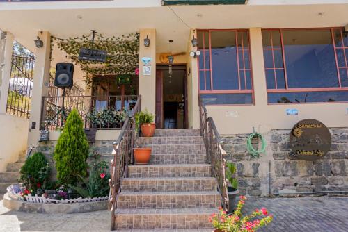 a house with stairs in front of it at SAMARIWASI CABAÑAS LODGE in Guaranda