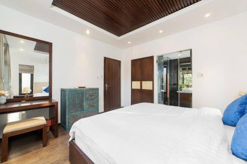 a bedroom with a bed and a desk and a mirror at The Yen Ocean Villa - Private An Bang Beach Villa in An Bang