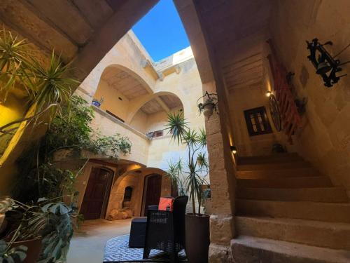 an entrance to a building with stairs and plants at Traditional House of Character in Gharb Gozo in Għarb